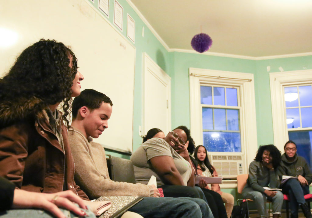 A group of youth sitting and laughing together in a meeting room